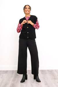 Front view of a women's black flat-knit layer with marled buttons, styled casually on a white background.