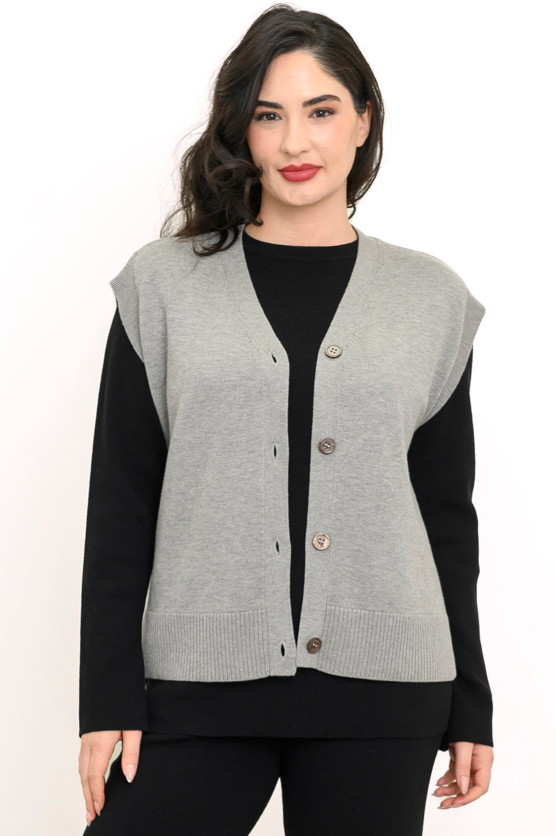 Smiling woman wearing a light gray fine-knit vest with a deep V-neckline and dark marled button closures.