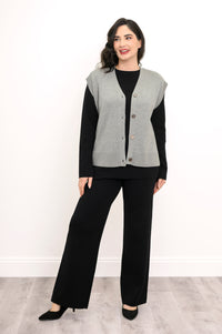 Front view of a pale gray buttoned knit layer paired with dark pants, highlighting a relaxed-fit drape.