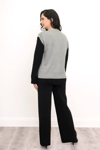 Back view of a light gray knit vest, highlighting the flattering extended shoulder cut and deep ribbed waist.