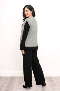 Side-facing view of a women's gray button-down vest styled with black pants against a plain white backdrop.