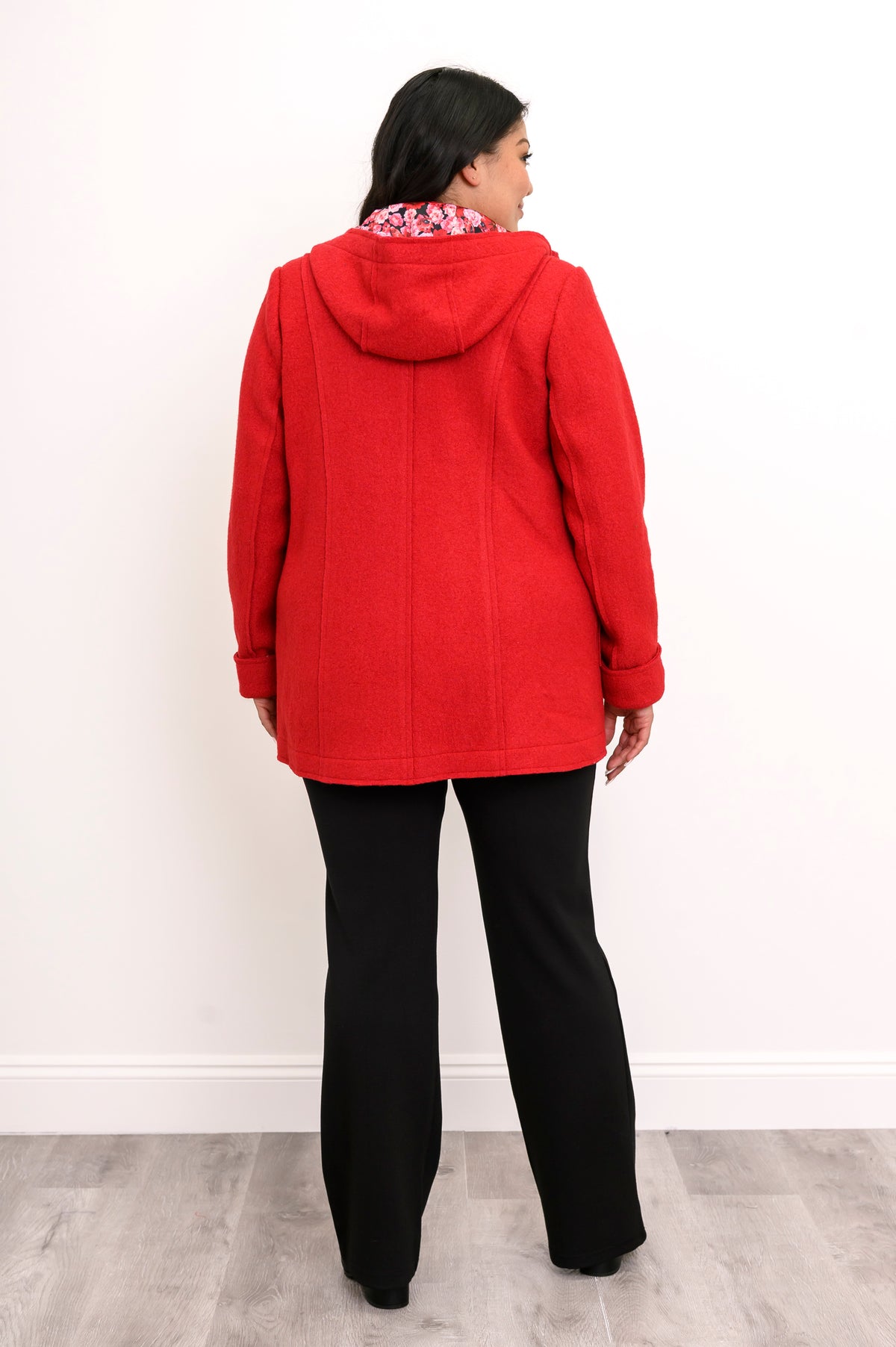 Back view of woman wearing bright red jacket showing red floral lining in the hood