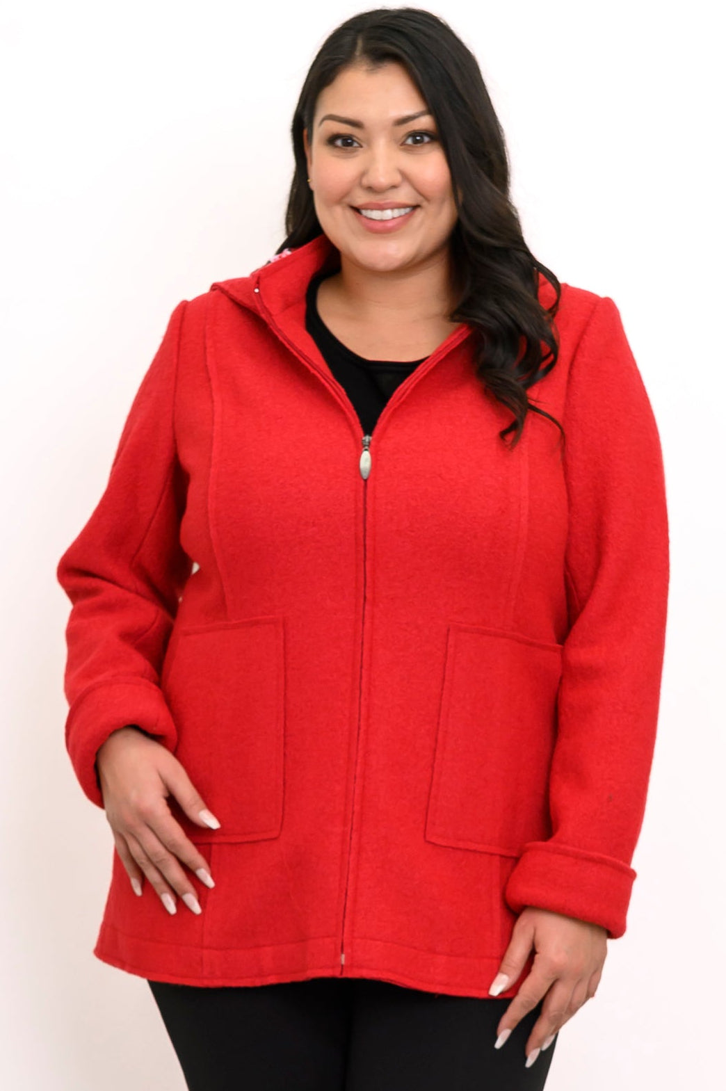 Woman wearing hip-length red zippered coat with hood and black pants on a white background, front view