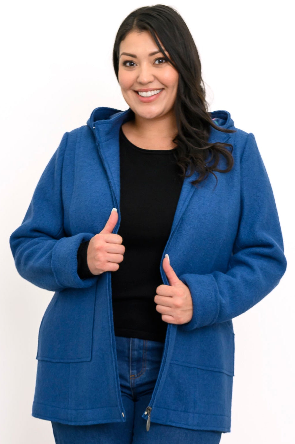 Woman wearing hip-length blue zippered coat with hood and denim pants on a white background, front view