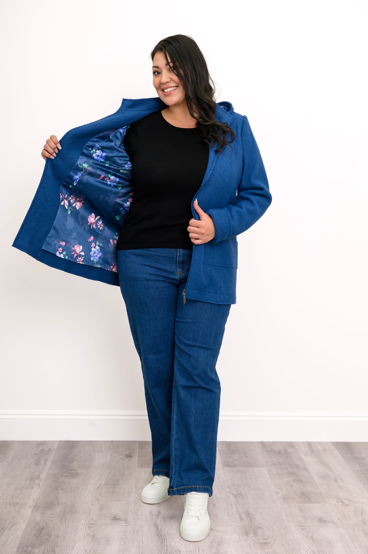 Woman showing off the satin blue floral lining of her cobalt blue zip-up jacket