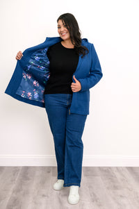 Woman showing off the satin blue floral lining of her cobalt blue zip-up jacket