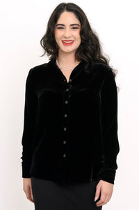 Front view of a smiling woman wearing a black silk velvet button-up shirt with a classic collar