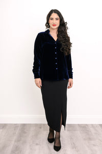 Wide studio shot of an elegant women's dark blue velvet long-sleeve blouse paired with a long black skirt and heels