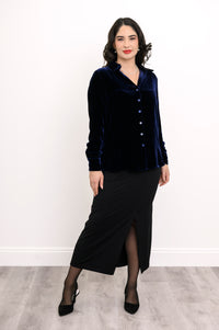 Full-length front view of woman wearing a navy blue silk velvet button-up shirt and a black maxi skirt
