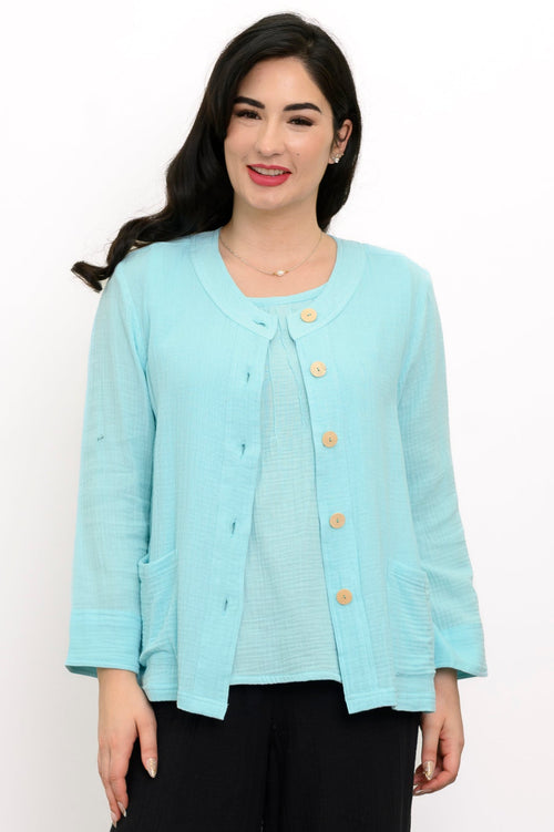 Woman wearing a light blue jacket on a light blue top and black pants on a white background, front view