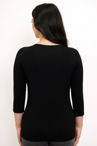 Back view of model wearing a black 3/4 sleeve top and grey pants against a white background