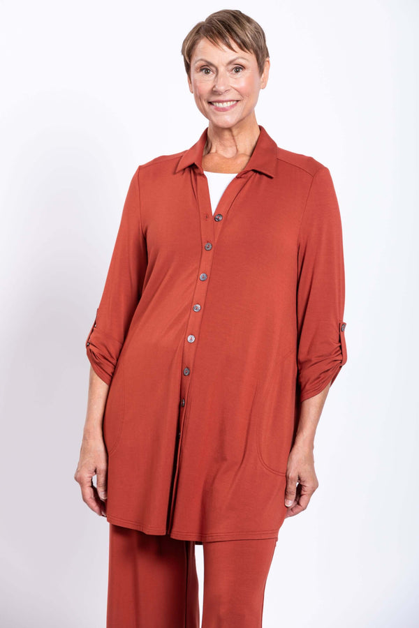 Woman wearing rust-colored Michele Bamboo French Terry blouse with adjustable sleeves