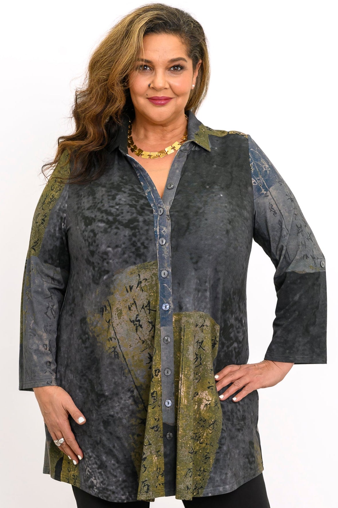 Green and grey patterned bamboo tunic  with collar and button details, styled with black pants.
