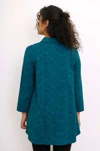 Rear view of a teal geometric print bamboo blouse, highlighting the shirt collar and comfortable hip-covering length.