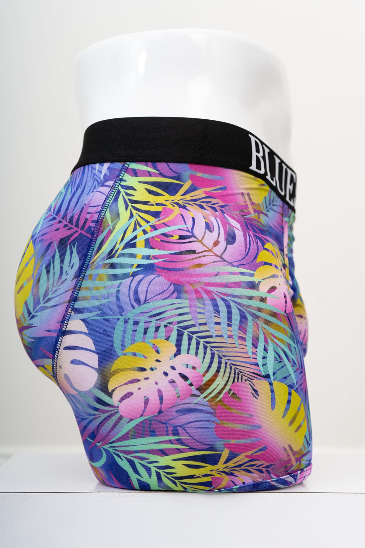 Side view of multicolour tropical leaf patterned men's underwear with an elastic waistband on a white background