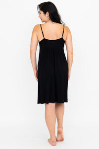 Back view of a woman wearing the black Mina Slip Dress.