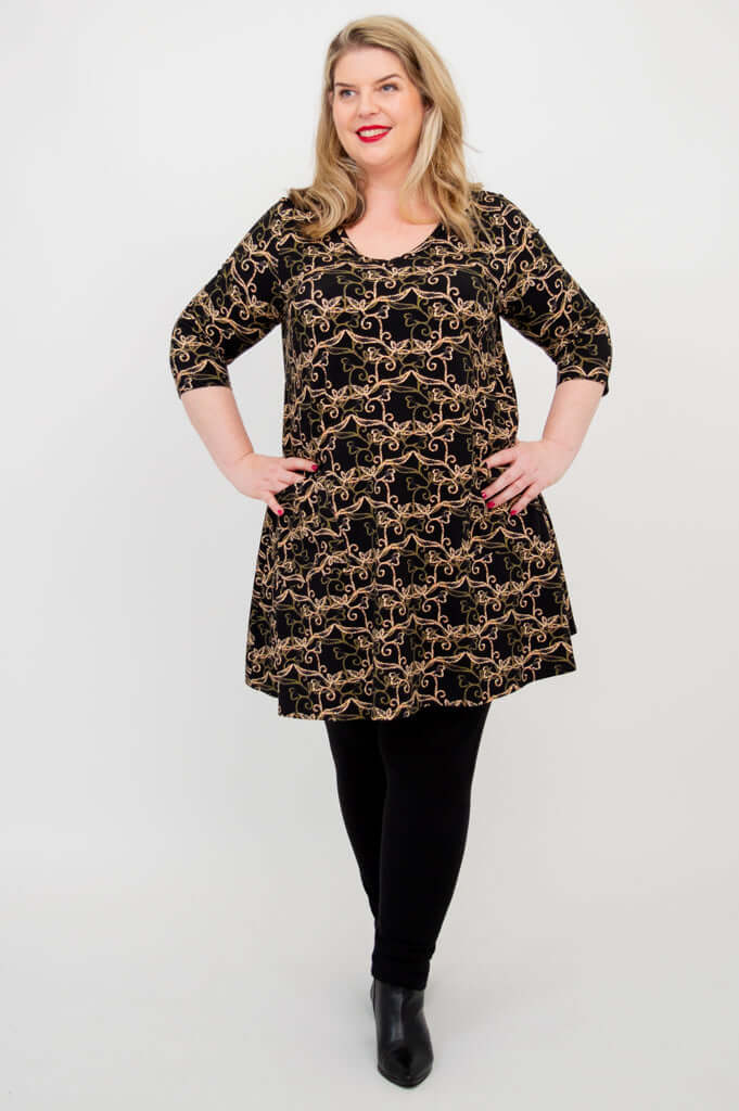 Model standing, wearing Veronica A-Line Tunic with black vine design and leggings