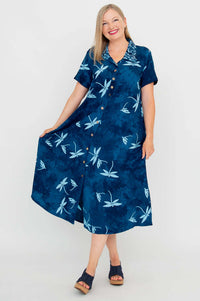 Woman holding out the skirt of a blue dragonfly print swing dress, showing button-up front