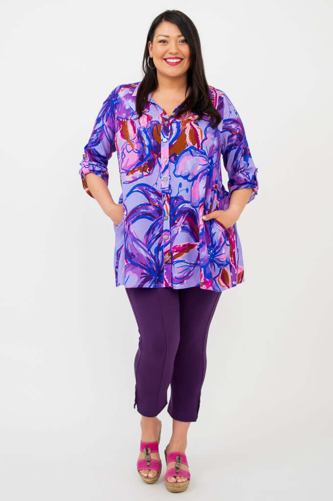 Model smiling in a Painted Iris print bamboo-linen tunic, hands in pockets, with rolled sleeves