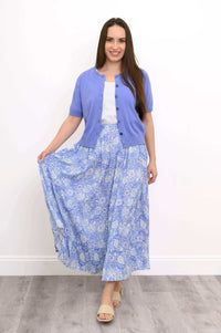 Woman holding out the hem of a blue tiered maxi skirt to show fullness