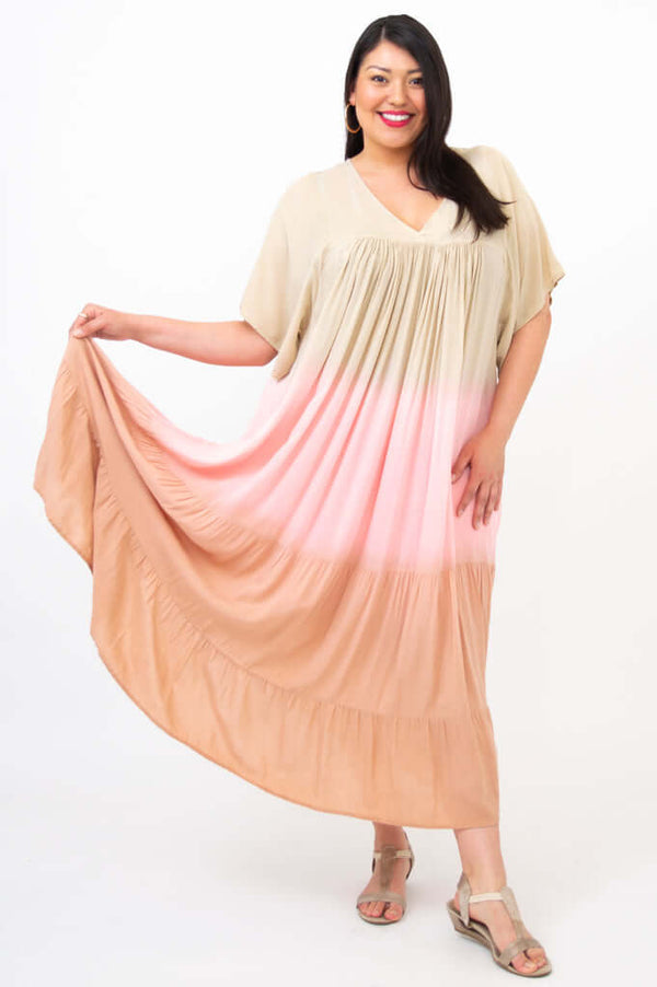 Front view of model holding out one side of the ombre tiered maxi dress