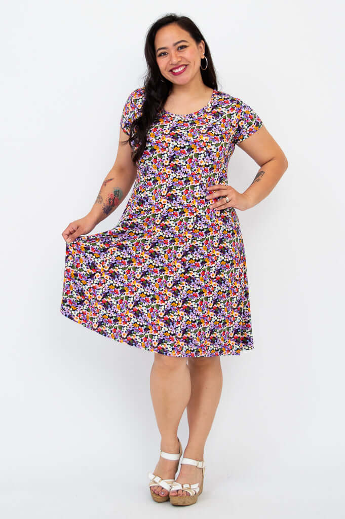 Model holding out the skirt of a floral A-line bamboo dress