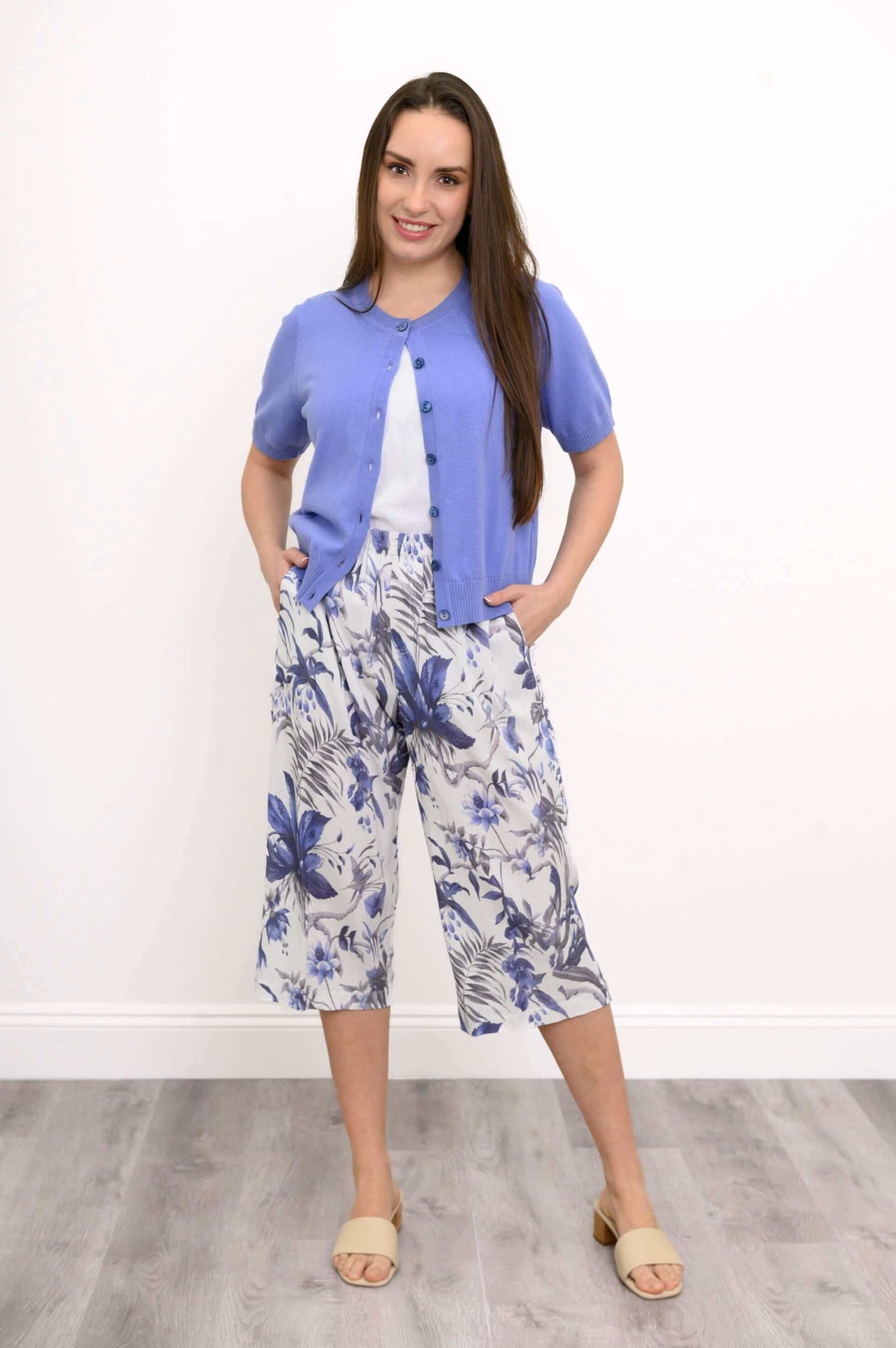 Model wearing blue floral Bella Capri Pant with purple short-sleeve cardigan