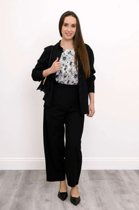 Model in Boardwalk Pants paired with a floral blouse, black jacket, and handbag