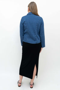 Woman wearing Eva skirt and blue shirt, back view