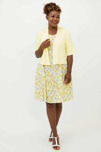 Woman modeling a yellow floral dress with a light yellow short-sleeve jacket