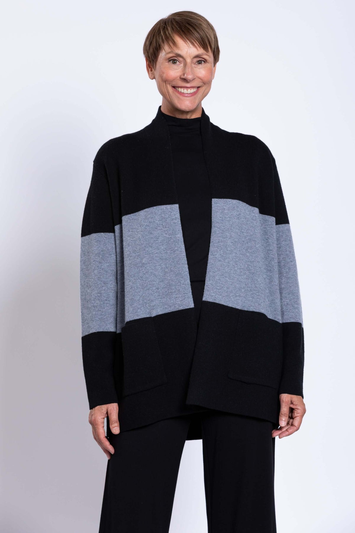 Model in black and grey colour-block sweater, close-up of front and sleeves