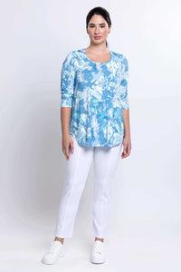 Full body front view of model in blue watercolor bamboo top and white pants