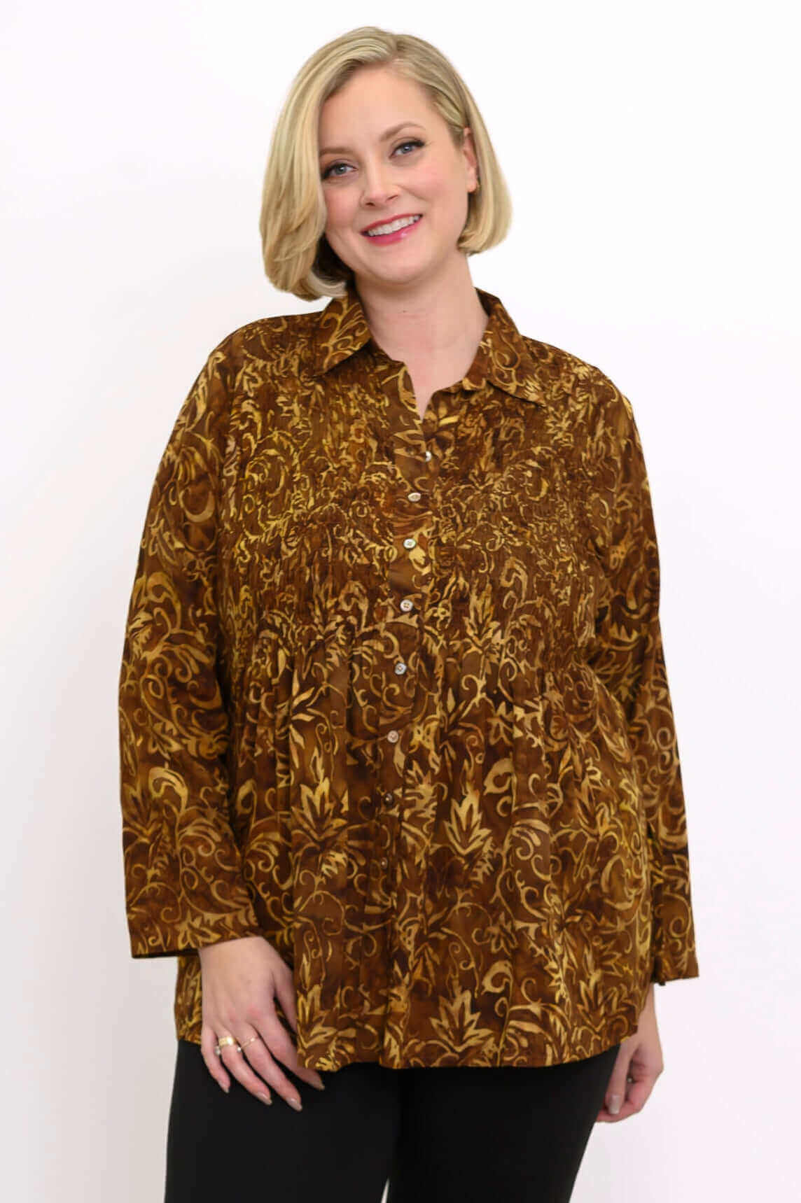 Model wearing brown floral long sleeve smocked shirt with button front, closeup