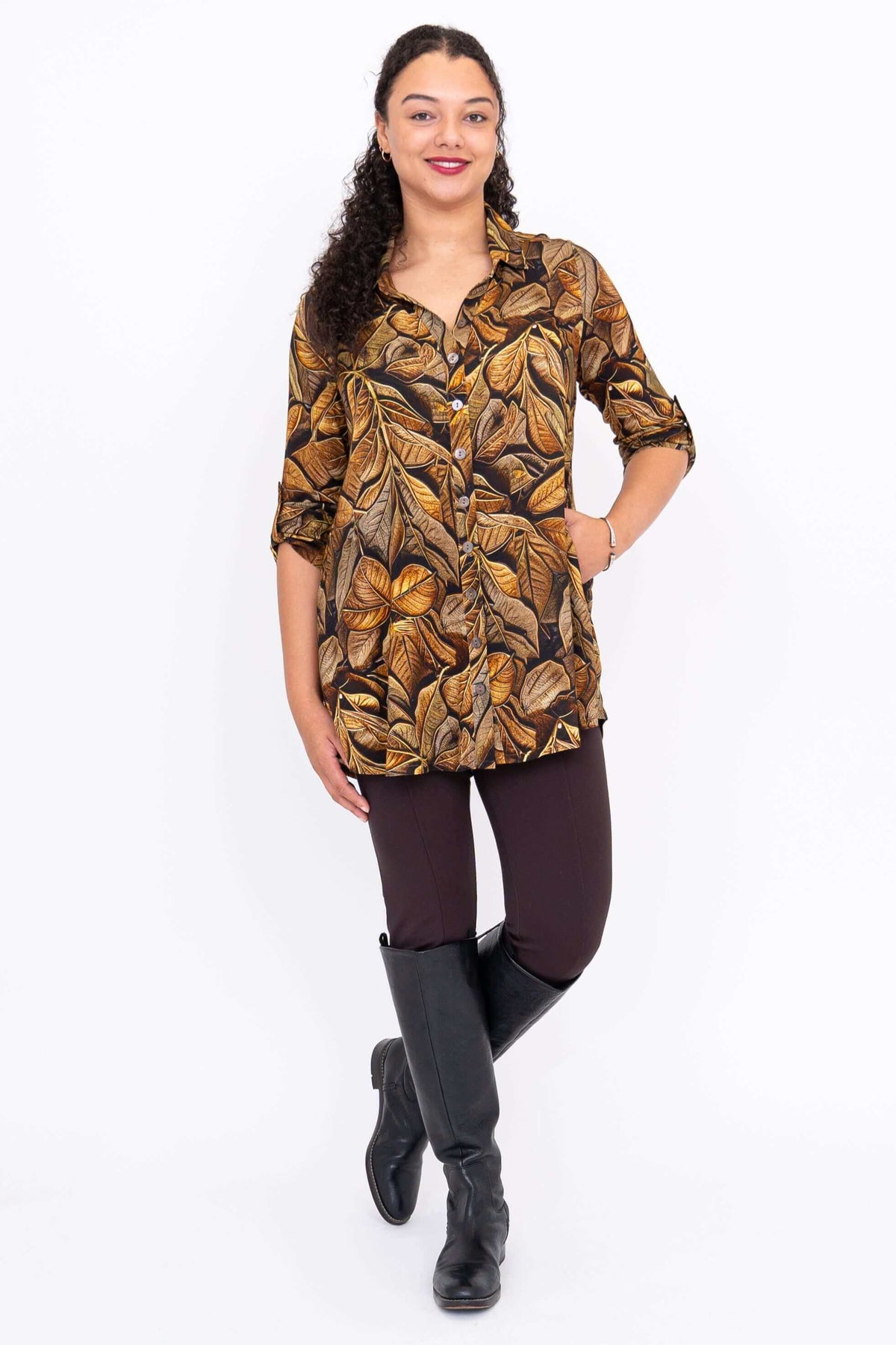 Model standing in autumn leaf tunic with hands in side seam pockets and black boots