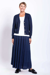 Model in navy Roma tiered maxi skirt and cardigan, standing and smiling