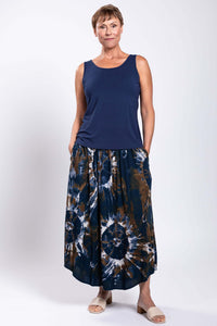 Model wearing navy sleeveless top and brown navy tie dye batik midi skirt, hands in pockets
