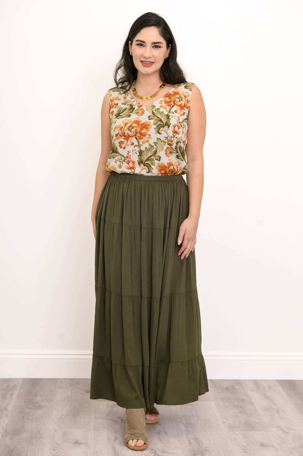 Model wearing an olive green tiered maxi skirt with a floral sleeveless blouse