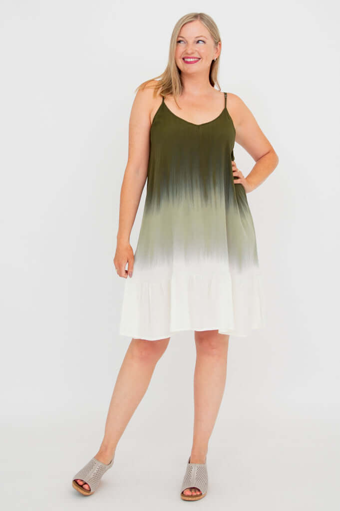 Woman posing in olive ombre mini dress with hand on hip and smiling