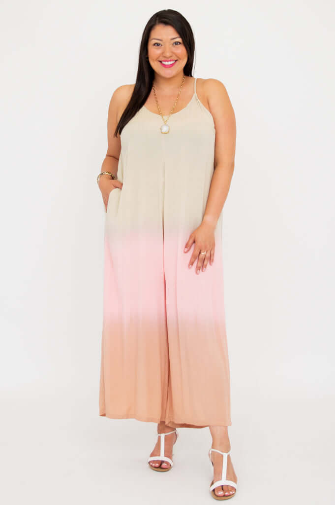 Model smiling and standing in a beige to blush ombre wide leg jumpsuit