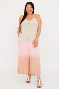 Model smiling and standing in a beige to blush ombre wide leg jumpsuit