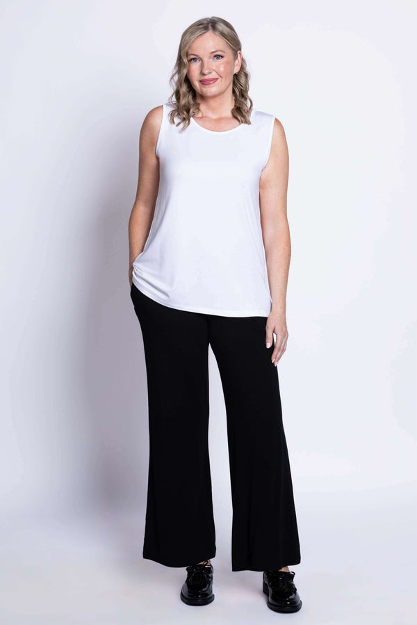 Model standing in white French Terry tank and black wide-leg pants, facing forward