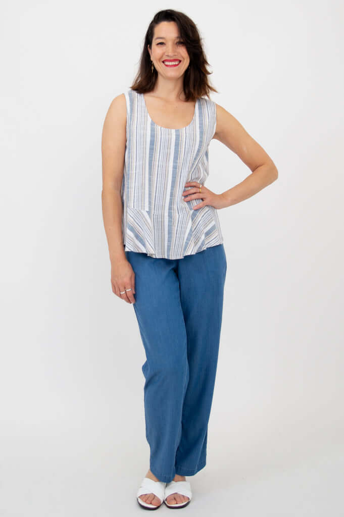 Model posing with hand on hip in Ginny Tank and blue pants