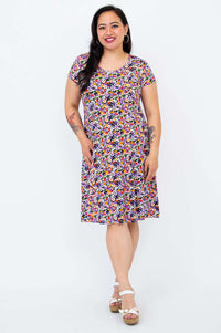 Model posing in a floral print short sleeve dress with a relaxed fit