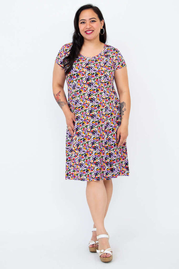 Model posing in a floral print short sleeve dress with a relaxed fit