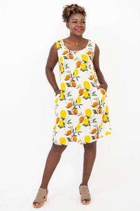 Woman with hands in pockets, posing in citrus print bamboo linen dress