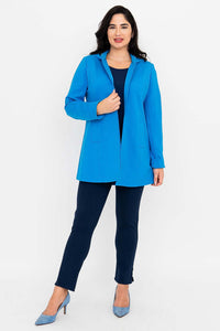 Woman in blue thigh-length coat, front view with coat unzipped