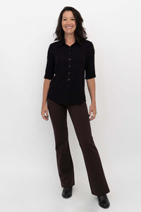 Model standing and smiling in Daya Flared Modal Pants in coffee and black top