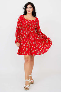 Model twirling in a red ditsy print dress, showing off the flowy full skirt