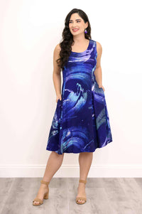 Model showing side pockets on abstract blue swirl sleeveless dress