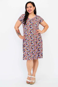Model smiling in a vibrant floral bamboo dress with short sleeves